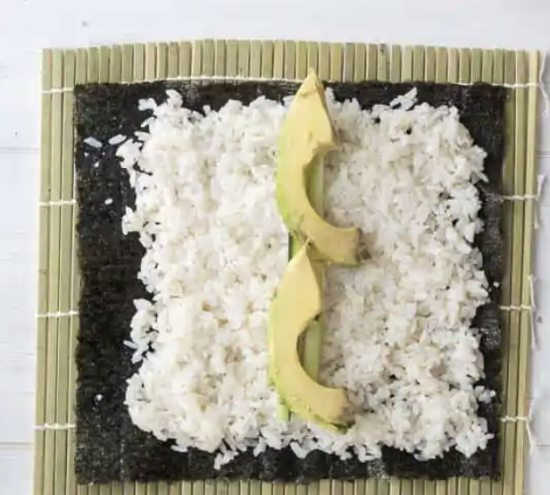 spreading contents onto sushi rice